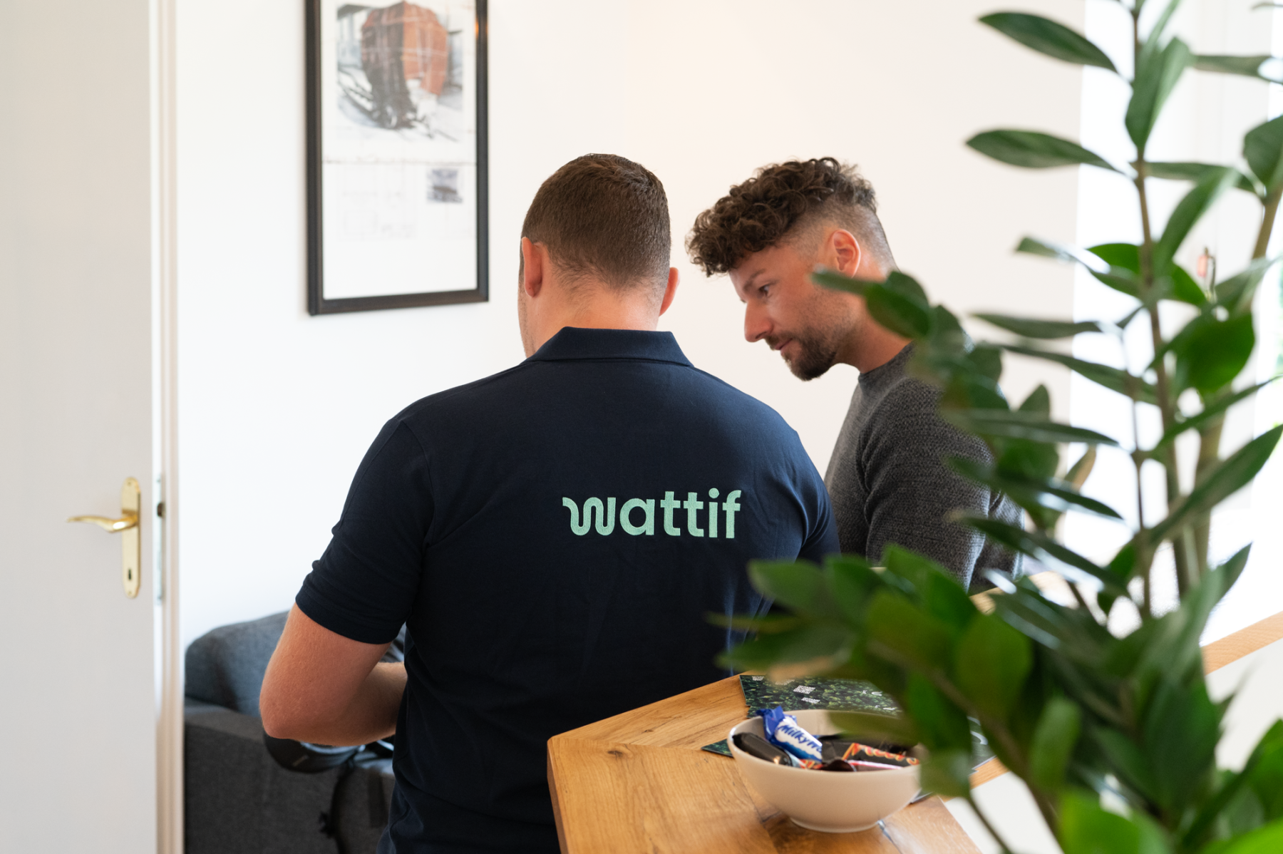 back of two men with wattif t-shirts on talking